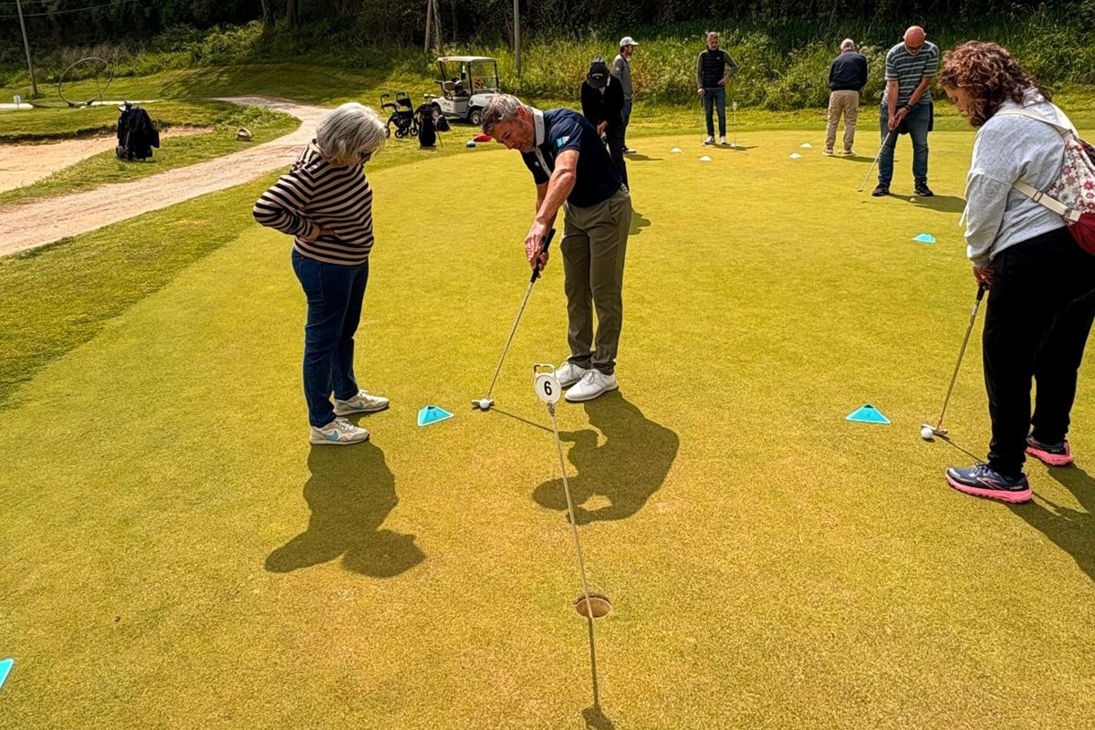 Socios practicando putting en un entrenamiento de golf adaptado